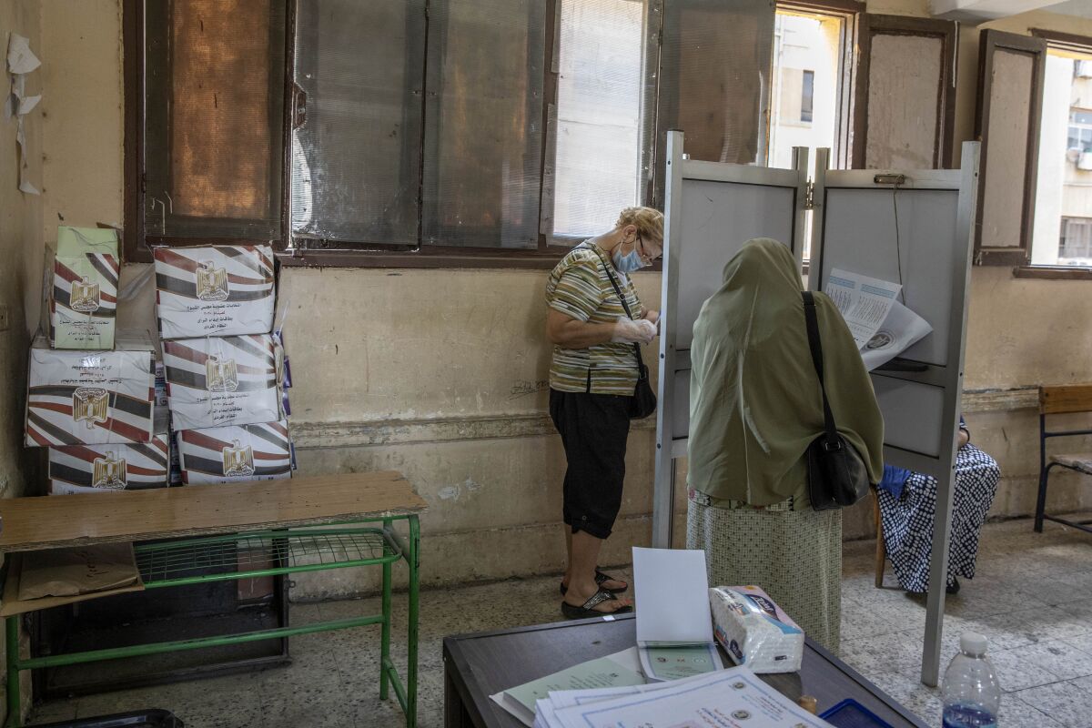 Women vote on the first day of the Senate elections inside a polling station in Cairo, Egypt, Tuesday, Aug. 11, 2020. Egyptians started voting on Tuesday for the Senate, the upper chamber of parliament that was revived as part of constitutional amendments approved in a referendum last year — an election that comes as the country faces an uptick in daily numbers of new coronavirus cases. (AP Photo/Nariman El-Mofty)
