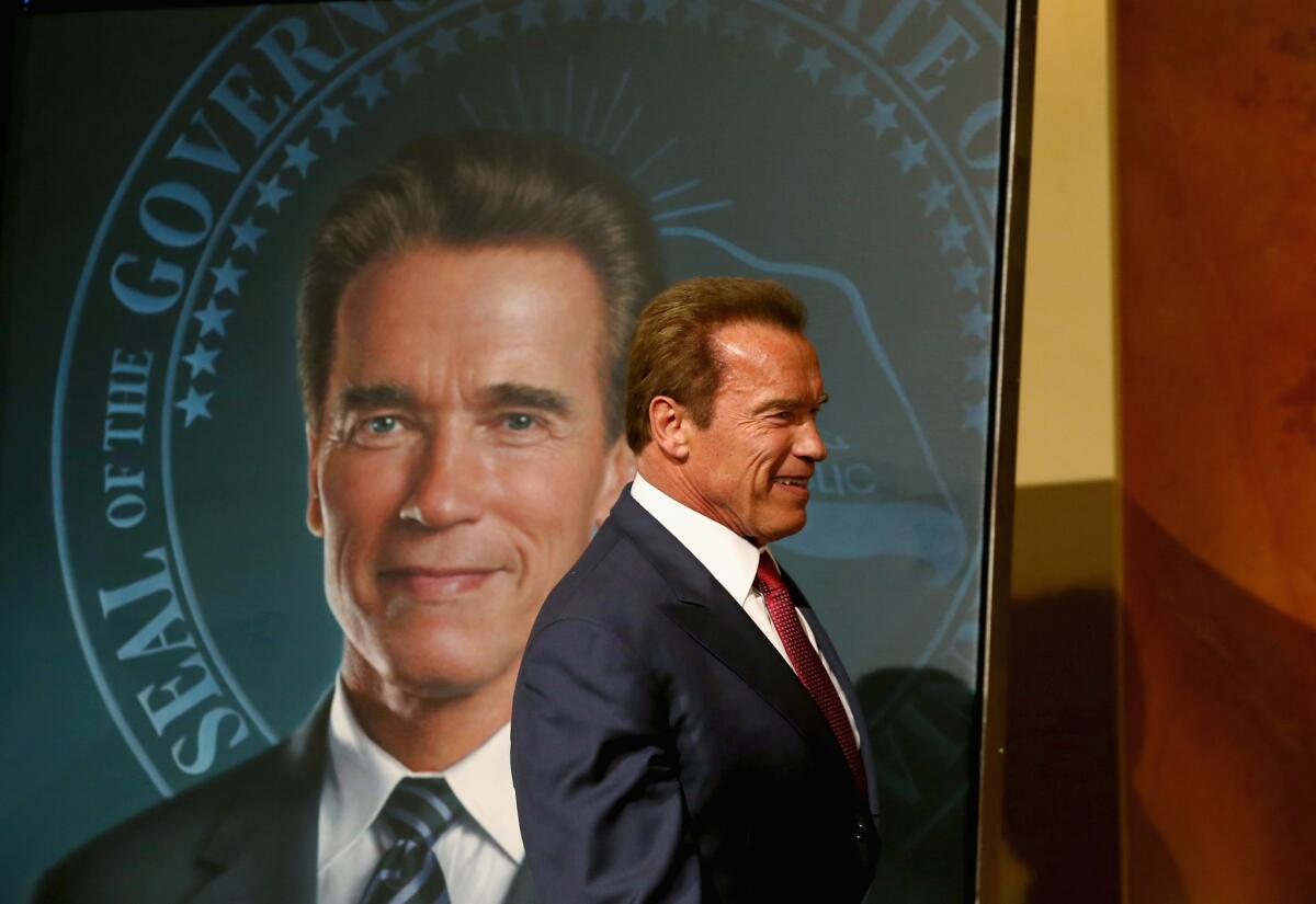 Former Calif. Gov. Arnold Schwarzenegger stands in front of his gubernatorial portrait at the unveiling in the Rotunda of the State Capitol in 2014.