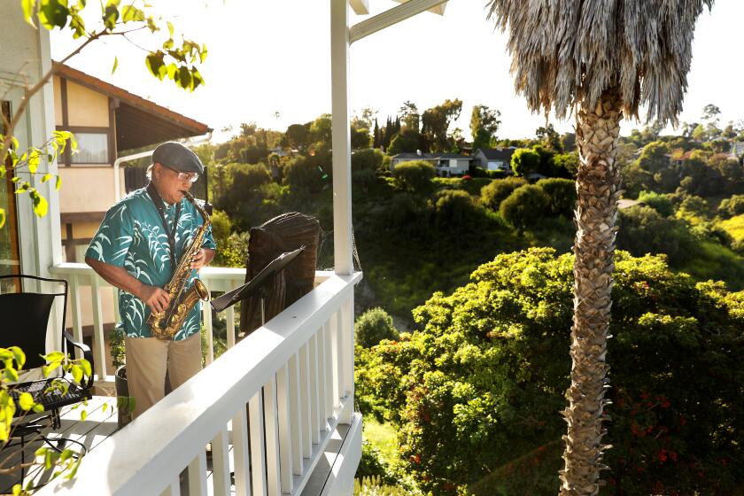 ROLLING HILLS ESTATES-CA-MAY 2, 2020: Leonard Pagarigan, 74, plays the saxophone on his deck at home in Rolling Hills Estates, California as the sun sets on Saturday, May 2, 2020, as he's been doing once or twice a week during the safer at home order. (Christina House / Los Angeles Times)