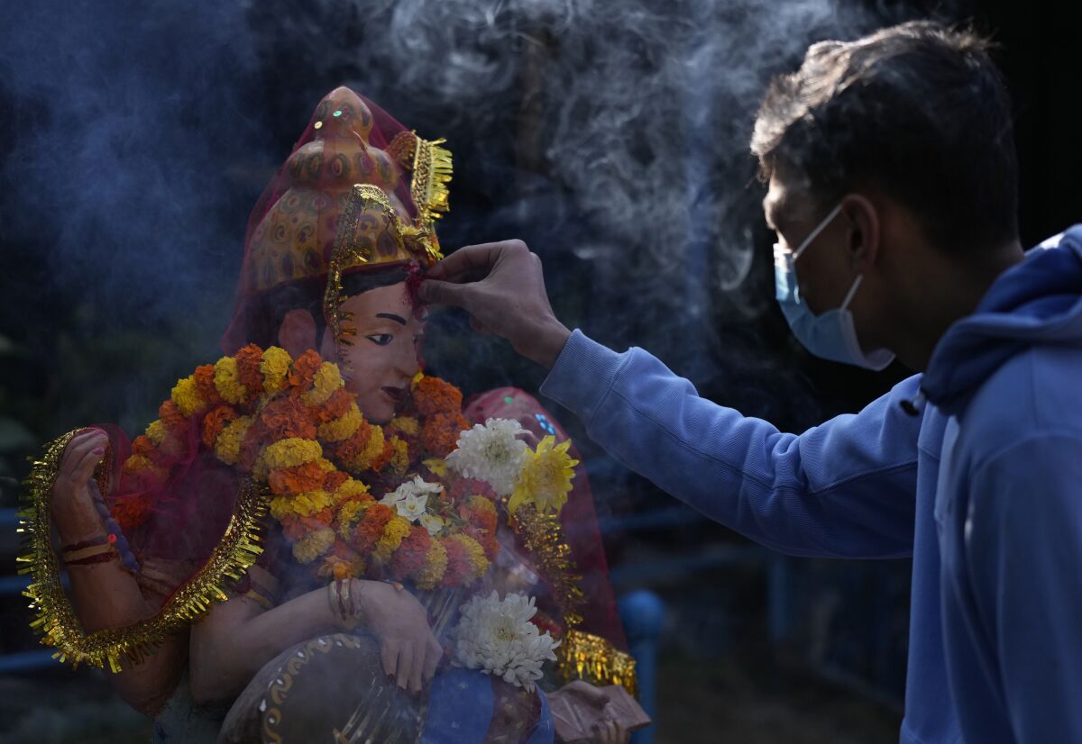 A Nepalese student offers prayers before a statue of Hindu goddess Saraswati at a school during Shri Panchami festival in Kathmandu, Nepal, Sunday, Feb. 6, 2022. Saraswati, the goddess of knowledge and learning is worshipped during this festival.Young children are also given their first reading and writing lesson on this day. (AP Photo/Niranjan Shrestha)