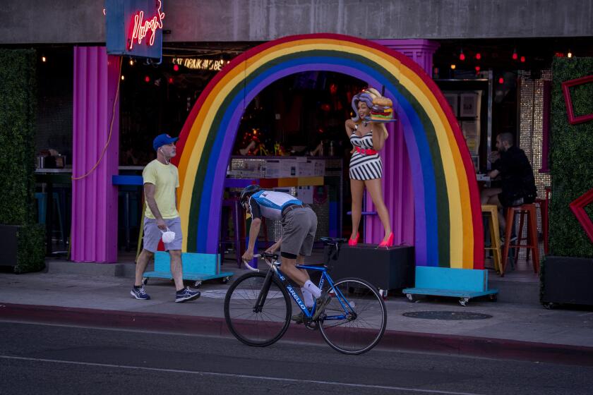 West Hollywood, CA - October 28: A person on a bike rides along Santa Monica Blvd. in West Hollywood at sunset Thursday, Oct. 28, 2021. (Allen J. Schaben / Los Angeles Times)
