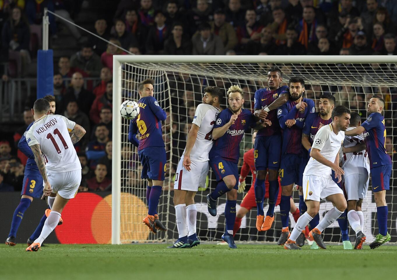 Roma's Serbian defender Aleksandar Kolarov (L) shoots against Barcelona's wall during the UEFA Champions League quarter-final first leg football match between FC Barcelona and AS Roma at the Camp Nou Stadium in Barcelona on April 4, 2018. / AFP PHOTO / LLUIS GENELLUIS GENE/AFP/Getty Images ** OUTS - ELSENT, FPG, CM - OUTS * NM, PH, VA if sourced by CT, LA or MoD **