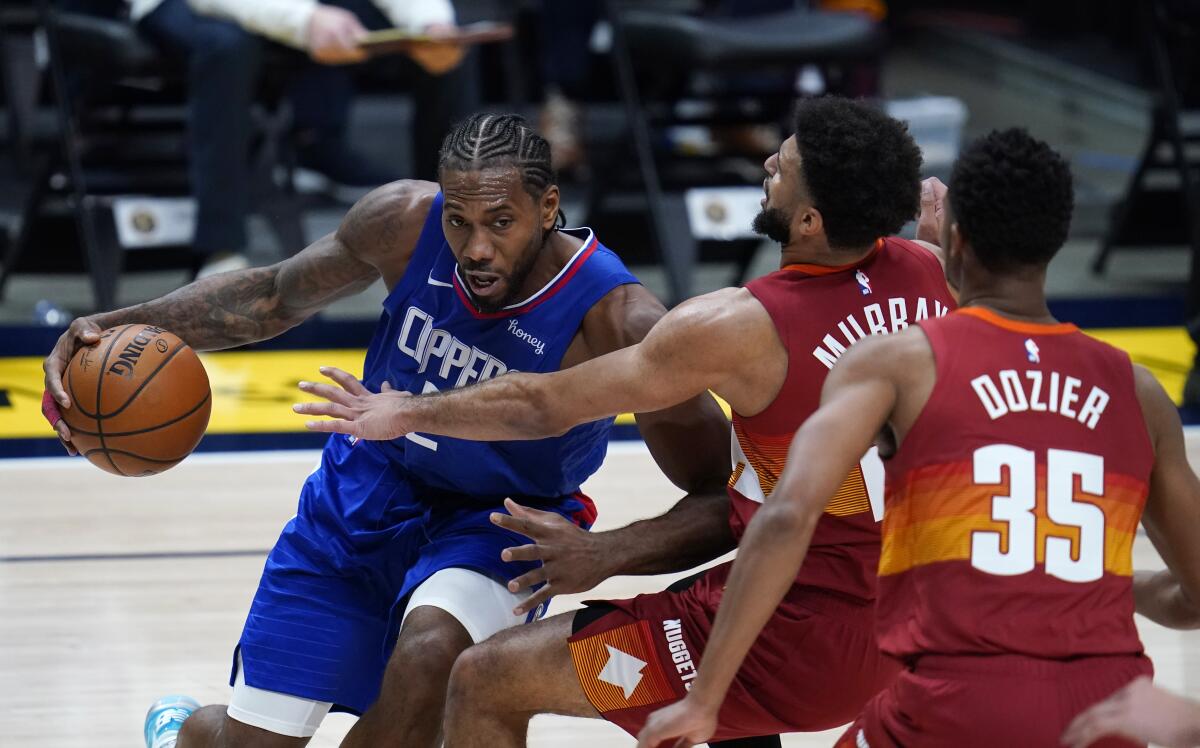 Clippers forward Kawhi Leonard is defended by Denver Nuggets guards Jamal Murray and PJ Dozier.