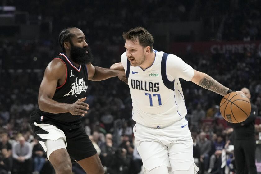 The Clippers' James Harden pressures the Mavericks' Luka Doncic, who is dribbling the ball 