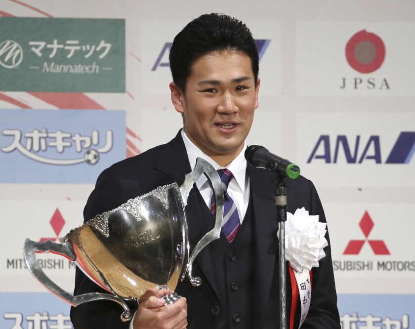 Japanese star pitcher Masahiro Tanaka poses with an award he won during a Japanese professional sports award ceremony in Tokyo on Friday.