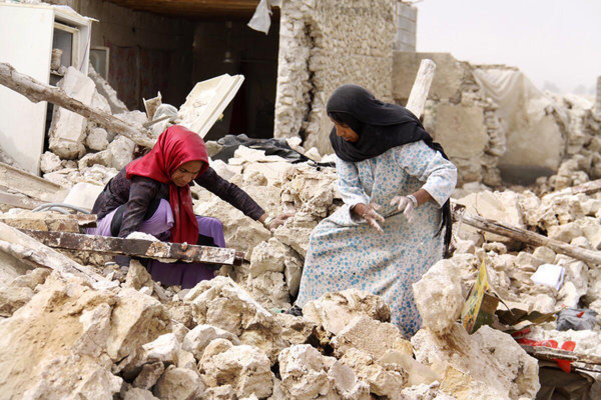 Iranians search through the rubble in the southern town of Shanbe.