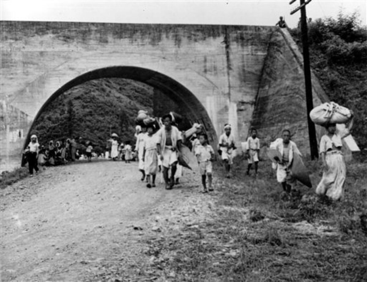 FILE - In this July 10, 1950 file photo, South Korean refugees are shown fleeing Taejon, South Korea, ahead of advancing North Korean troops early in the Korean War. In a political about-face, a South Korean commission investigating a century of human rights abuses, including the U.S. military's large-scale killing of Korean War refugees, has ruled the Americans in case after case acted out of military necessity. In a small number of cases, in which hundreds of innocent civilians were killed, a commission majority found "low levels of unlawfulness" by the U.S. military, but did not recommend seeking compensation. (AP Photo/File)