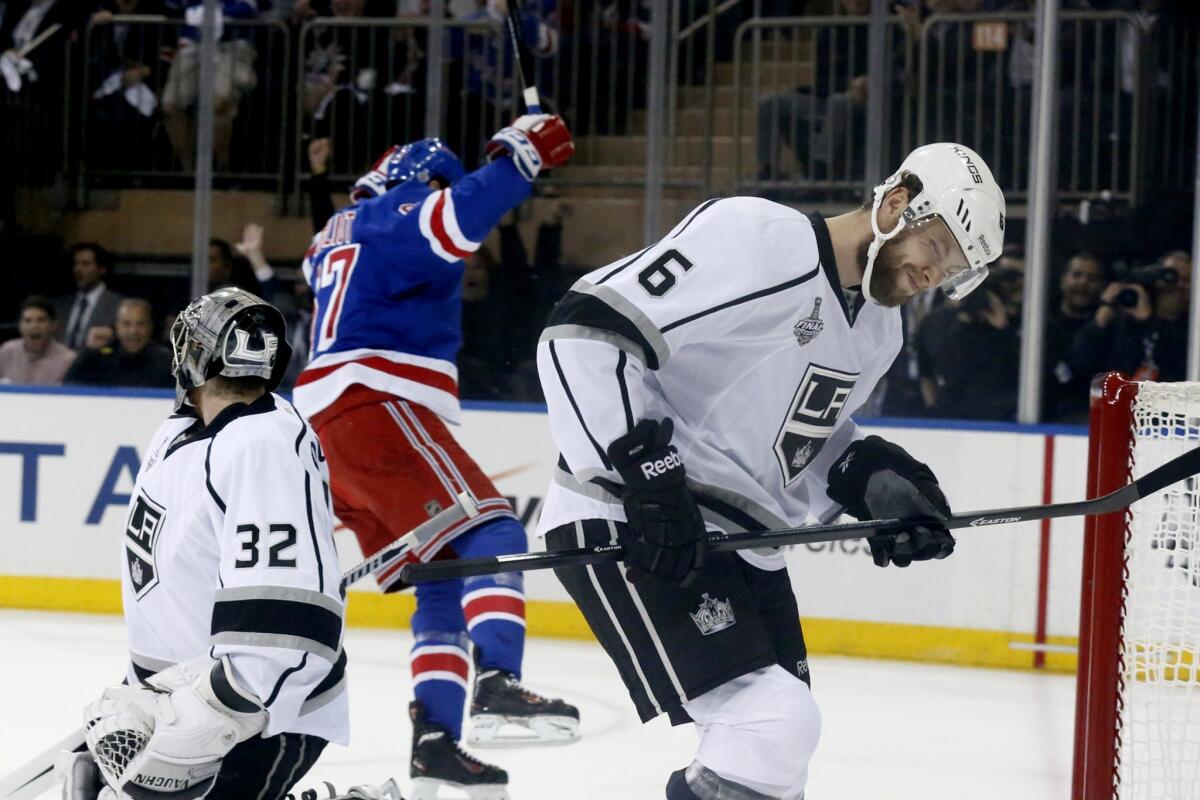 New York Rangers forward Benoit Pouliot, center, celebrates after scoring past Kings goalie Jonathan Quick and defenseman Jake Muzzin, right, during the first period of Game 4 of the Stanley Cup Final.