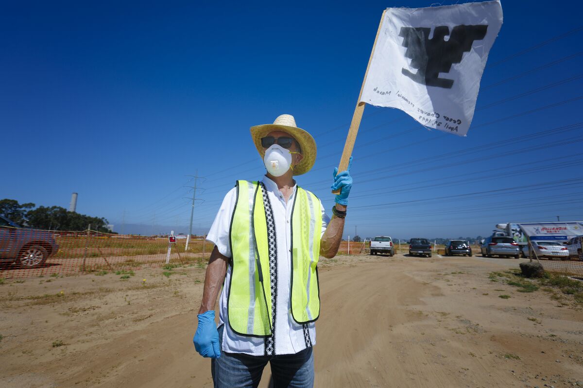 Roger Cazares held a United Farms Workers flag at the food donation drive held on Saturday in Carlsbad.