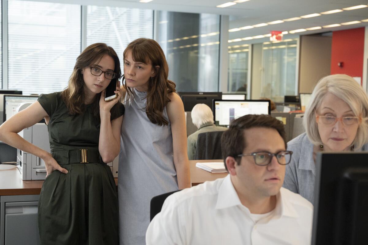 A group of reporters and editors standing by a newsroom computer