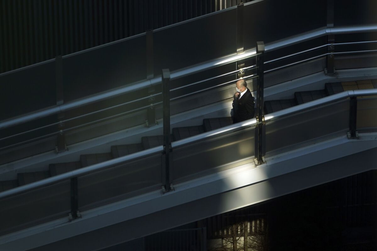 A man with a protective mask walks on a pedestrian bridge on Feb. 27 in Tokyo.