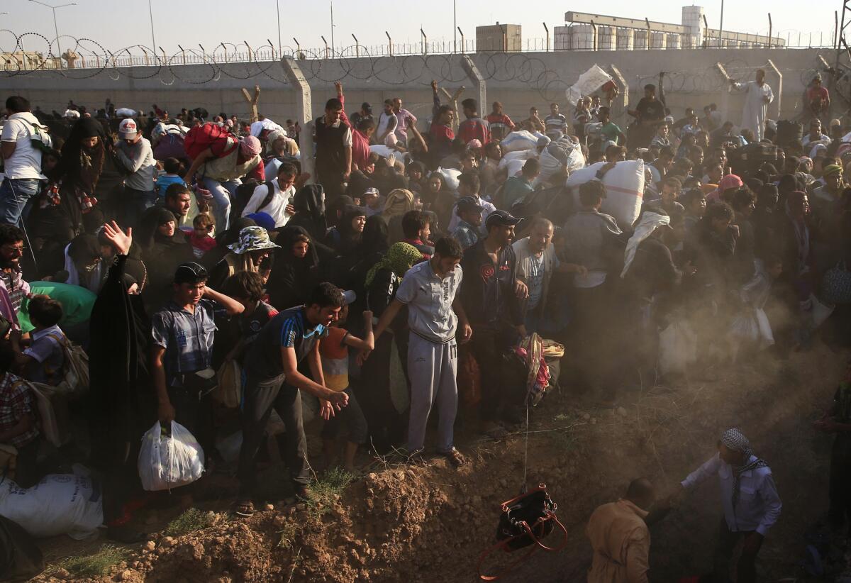 Syrian refugees are stuck after breaking the border fence and crossing into Turkey from Syria, in Akcakale.