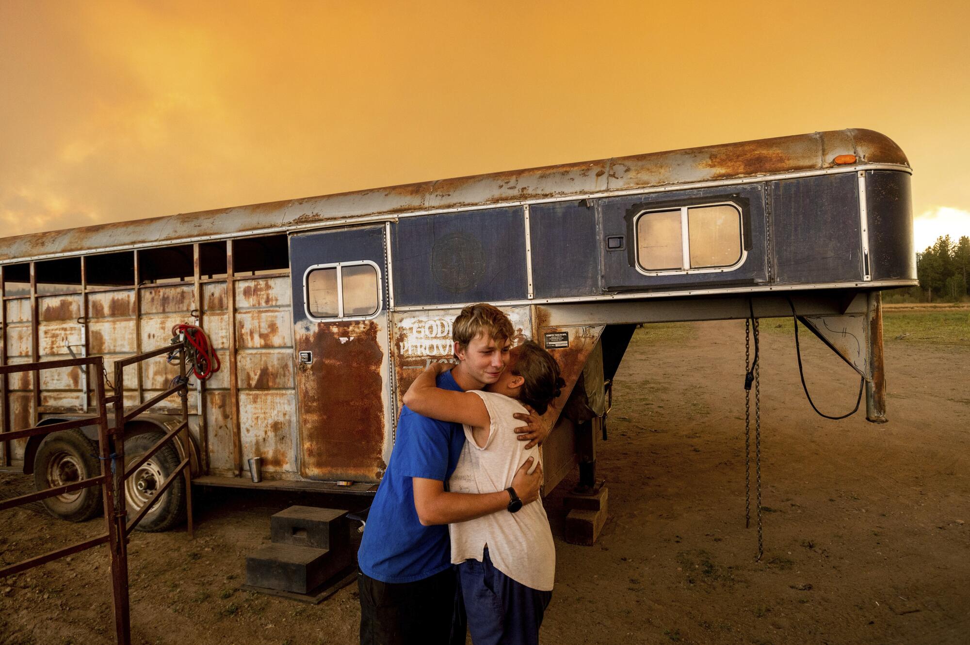 Hunter McKee hugs Dawn Garofalo in front of a horse trailer.