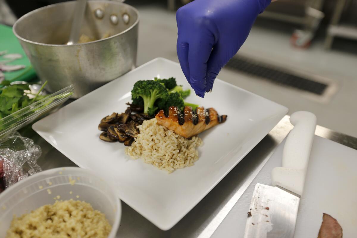 A plate of grilled teriyaki chicken with sautéed mushrooms, brown rice and broccoli is one of the meals for the elderly prepared at the L.A. Kitchen.