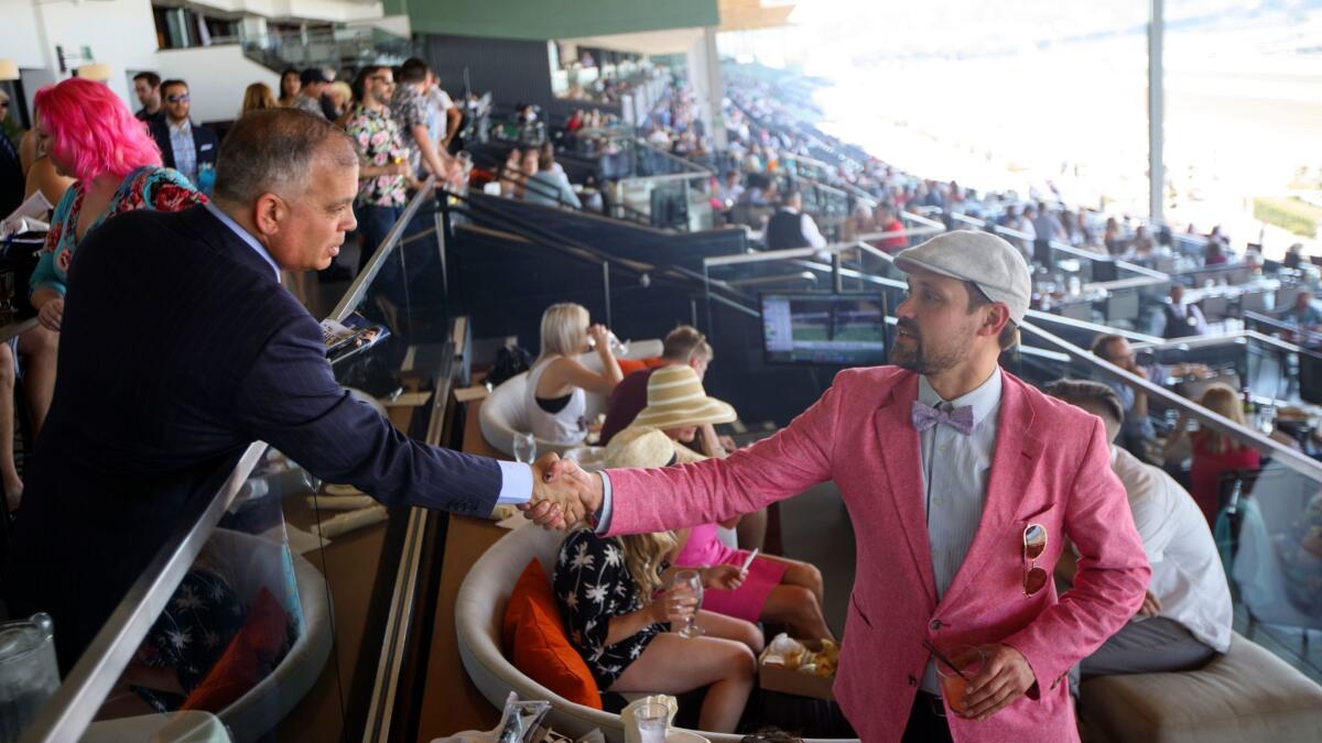 Santa Anita head Tim Ritvo shakes hands with customer Mike Duff on June 3.