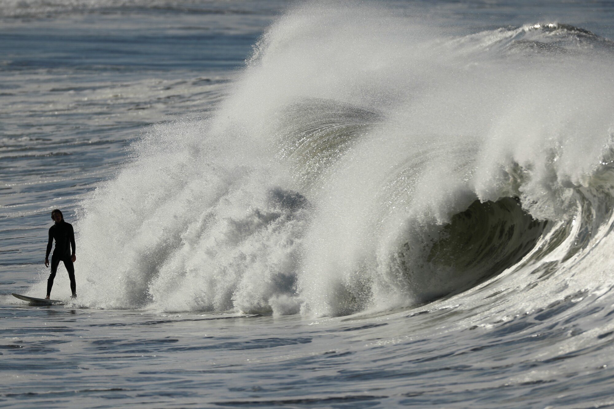 A surfer rides a wave on a warm day in Imperial Beach in 2021.  