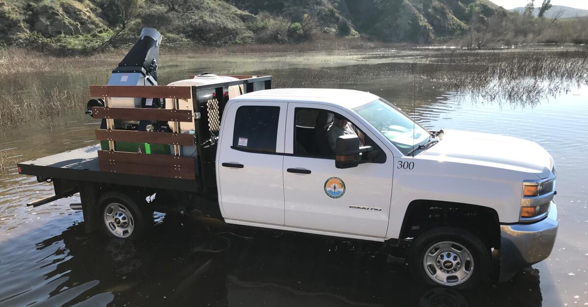 An Orange County Mosquito and Vector Control crew sprays larva-killing bacteria in Costa Mesa.