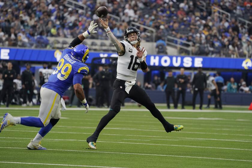 Jacksonville Jaguars quarterback Trevor Lawrence (16) throws over Los Angeles Rams defensive end Aaron Donald (99) during the first half of an NFL football game Sunday, Dec. 5, 2021, in Inglewood, Calif. (AP Photo/Mark J. Terrill)