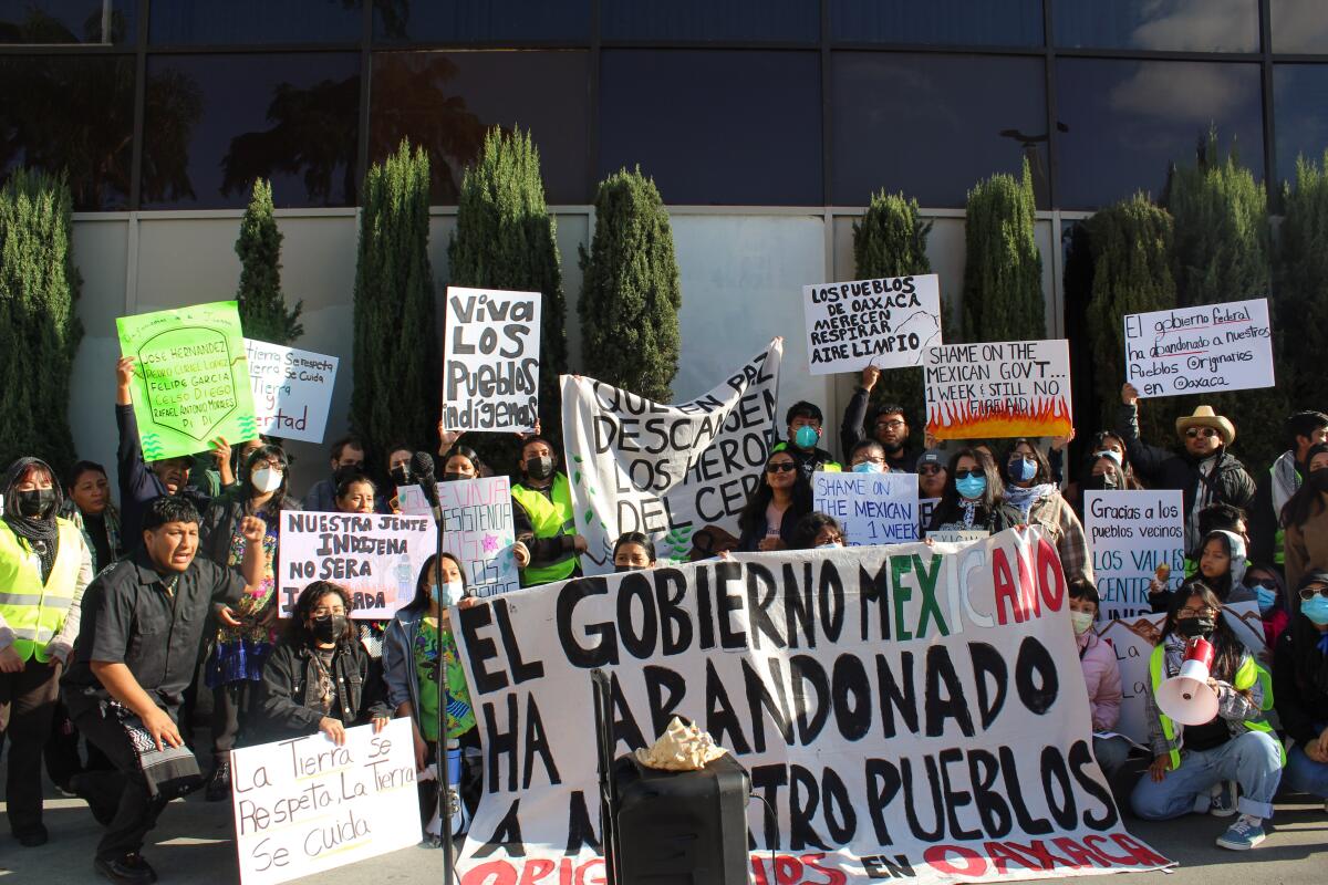 Young people hold signs protesting the Mexican government's response to wildfire