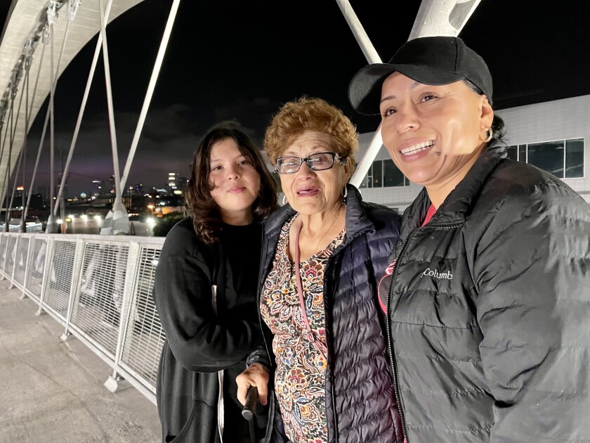 Three people on a bridge.