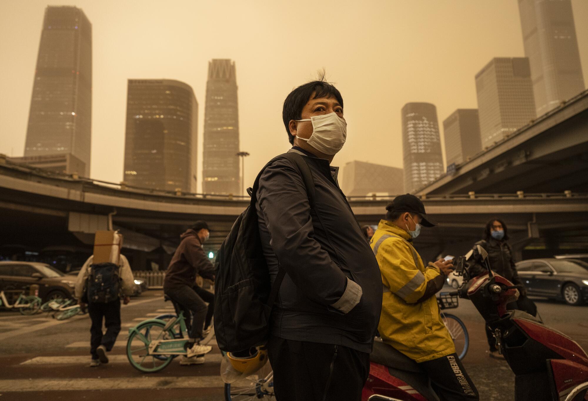 People wear face masks in a hazy city.