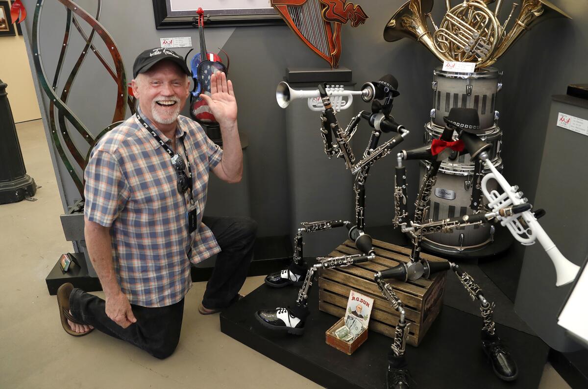 Sculptor Ken Jones stands next to his signature pieces, musician men made of old clarinets, at the Laguna Art-A-Fair.