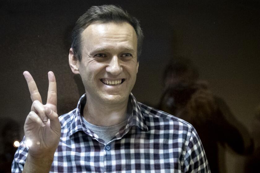 FILE -- Russian opposition leader Alexei Navalny gestures as he stands behind a glass panel of a cage in the Babuskinsky District Court in Moscow, Russia, Saturday, Feb. 20, 2021. On the second anniversary of the poison attack on Alexei Navalny, Germany and the United States have recalled the fate of Kremlin critic Alexei Navalny who is imprisoned in Russia. German Chancellor Olaf Scholz praised the Russian opposition politician’s courage in a video message Saturday. (AP Photo/Alexander Zemlianichenko,file)