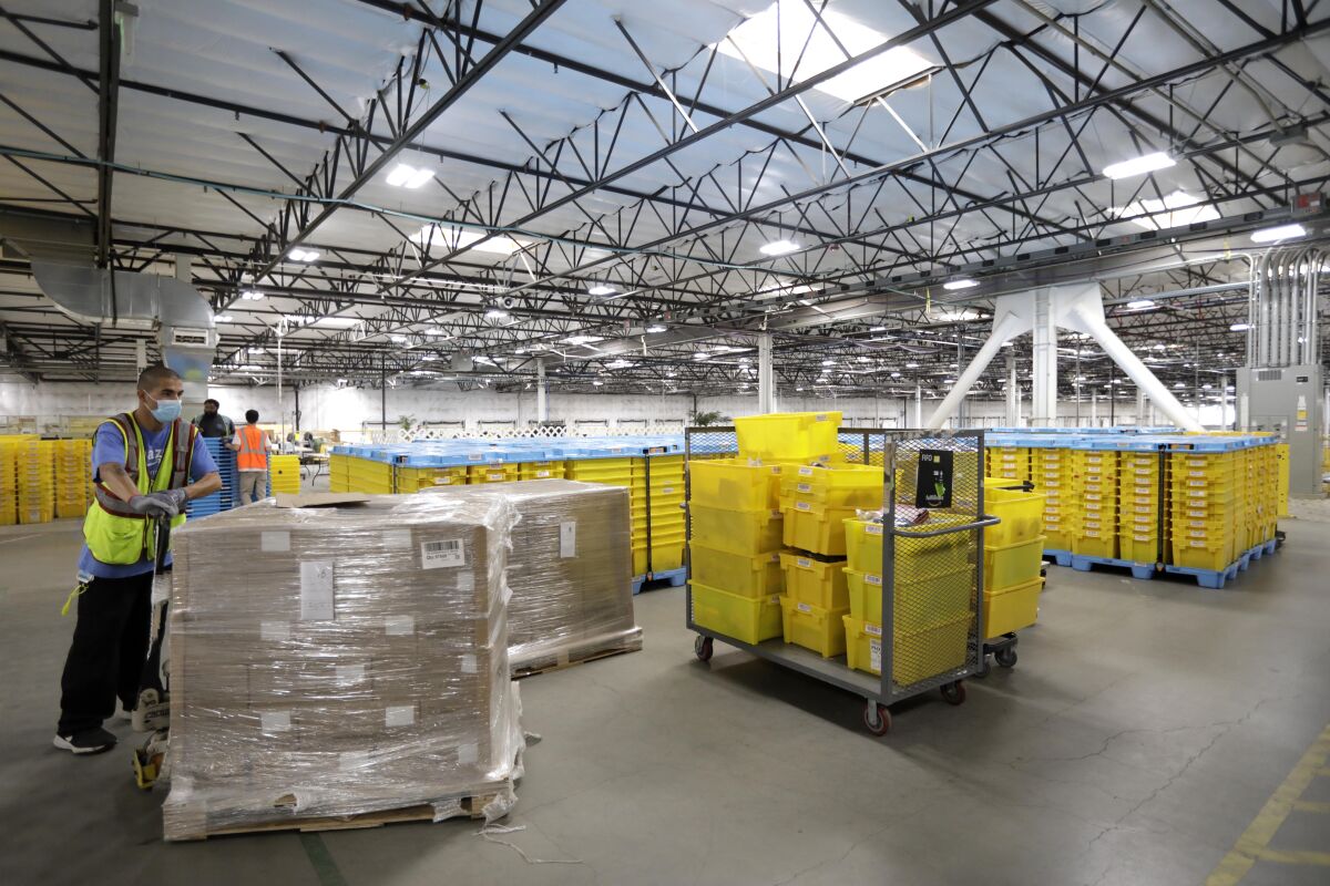 An employee works among parcels at an Amazon Fulfillment Center.