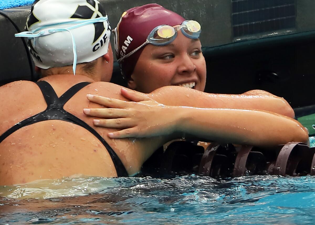 Ocean View's Morgan Carles hugs champion Ava Otteson of Xavier Prep after the Division 3 girls' 100 freestyle on Friday.