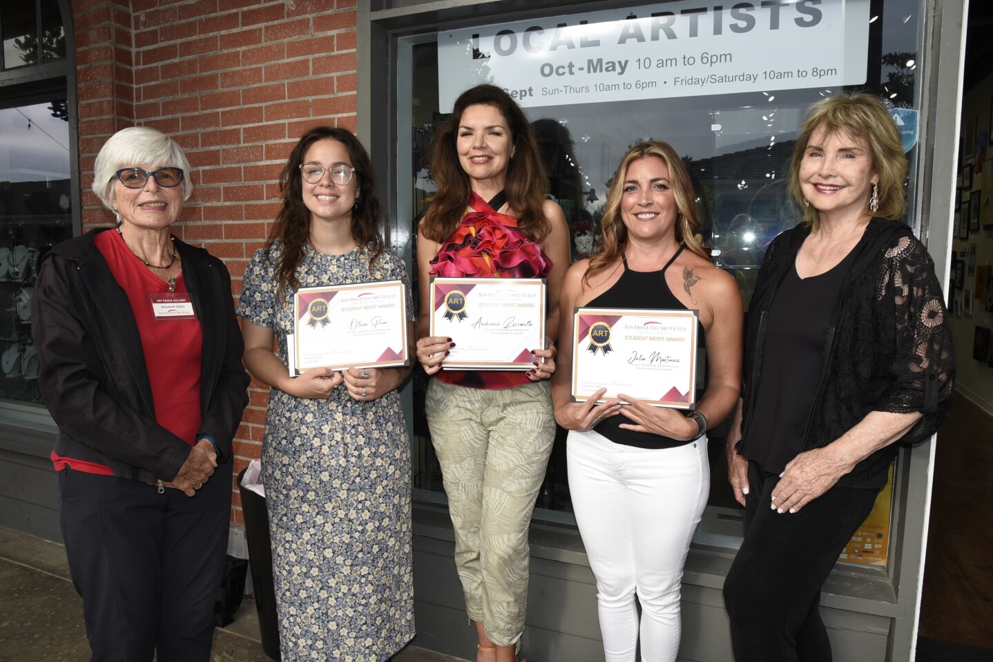 Off Track Gallery Fundraising Chair Elizabeth Gilpin presents awards to Mira Costa College artists Olivia Prior, Adriana Rossarolla, and Julia Martinez, as their art Professor Kris Nugent proudly joins them