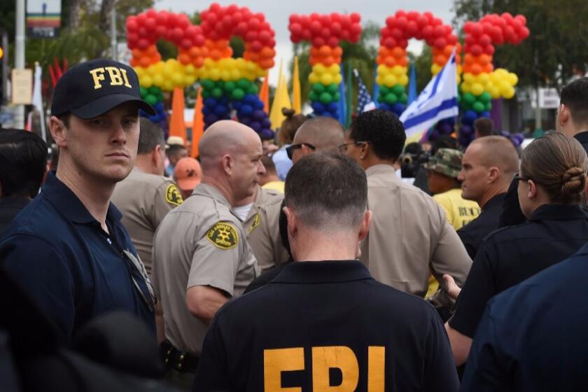 FBI agents keep watch during the L.A. Pride parade in West Hollywood on Sunday.