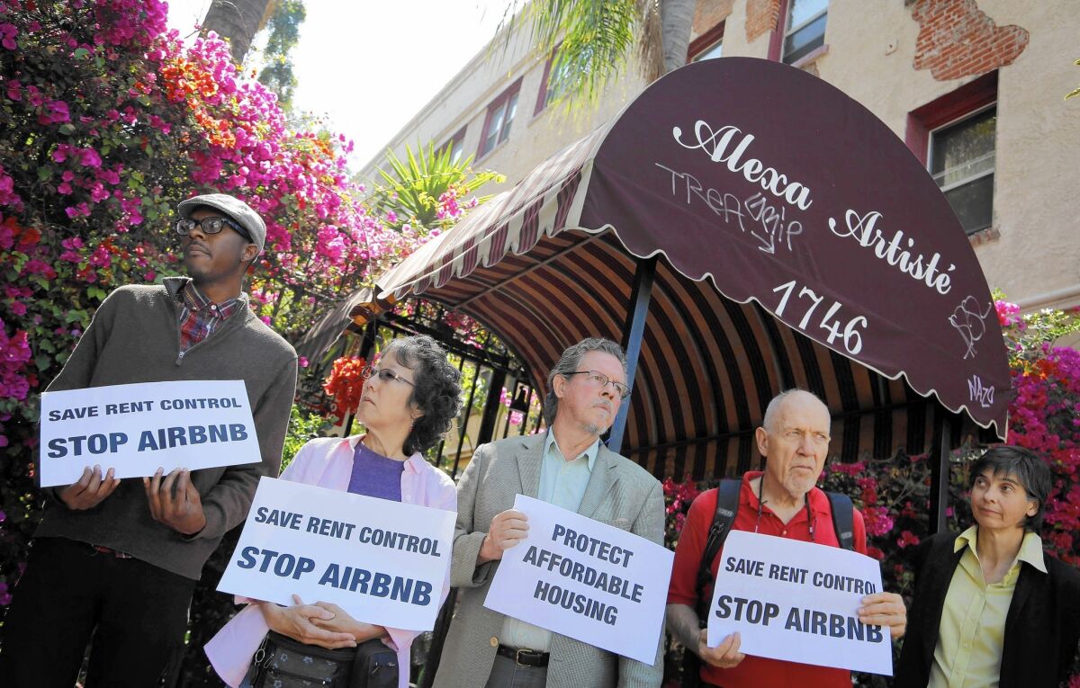 Housing and labor activists on July 15 protest outside a Hollywood apartment building that they say is being used for Airbnb rentals.