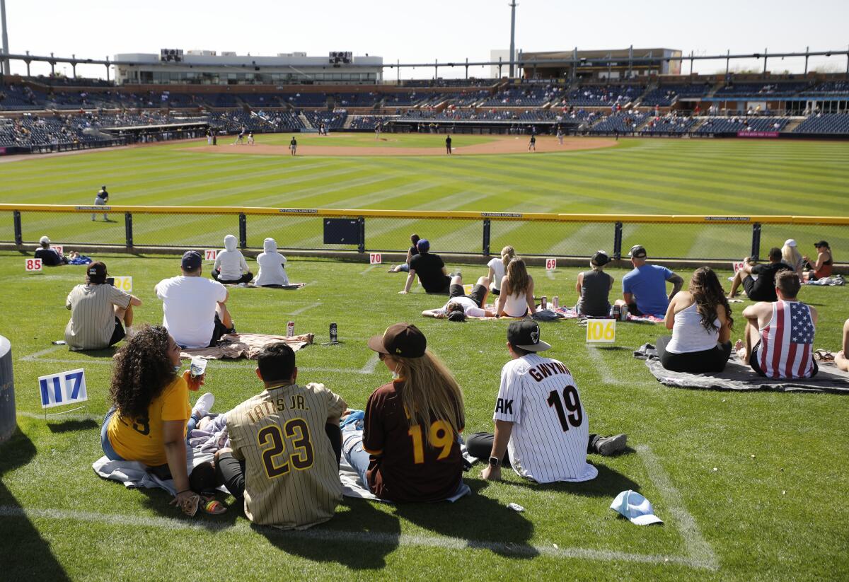Padres fans sit in the grass beyond the outfield fence Wednesday against the Brewers