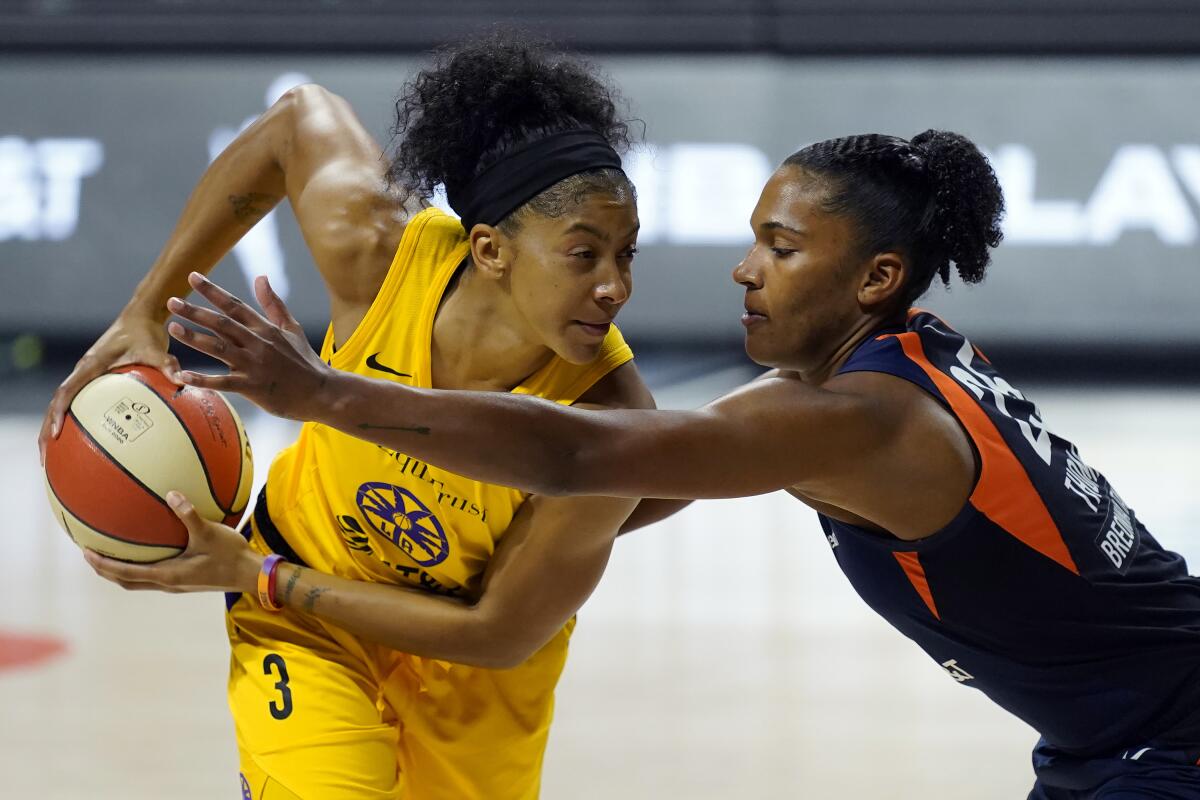 Sparks forward Candace Parker tries to keep the ball away from Connecticut Sun forward Alyssa Thomas.