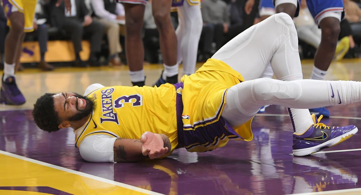 Lakers forward Anthony Davis winces after taking a fall during the third quarter of a game against the New York Knicks on Tuesday at Staples Center. 