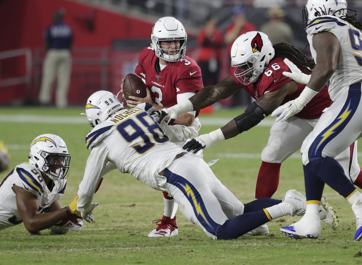 Arizona quarterback Josh Rosen is hit by Chargers linebacker Uchenna Nwosu (58) and defensive end Isaac Rochell (98) on Aug. 11.