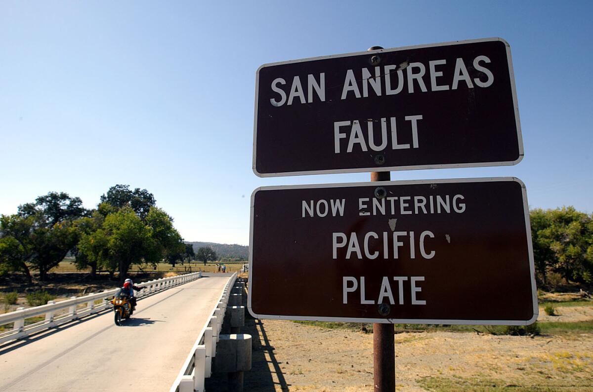 A file photo shows a sign in Parkfield, Calif., advising motorists they are crossing over the San Andreas fault.