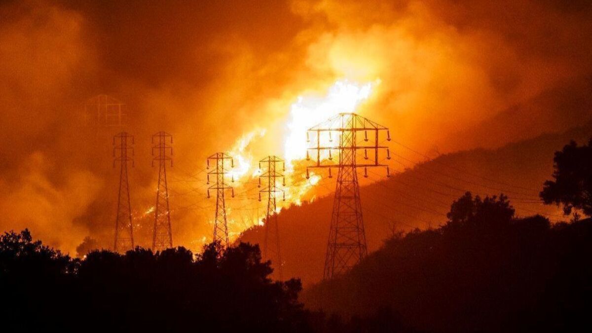 Flames from the Thomas fire whip around utility power lines in Sycamore Canyon on Dec. 16, 2017. Southern California Edison power lines were found to have sparked the deadly blaze.