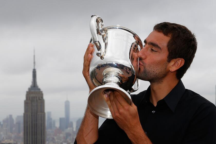 Maric Cilic kisses the winner's trophy from the 2014 U.S. Open at the Top of the Rock Observation Deck at Rockefeller Center.