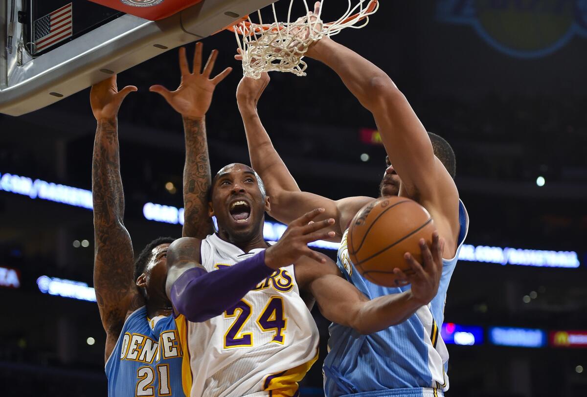 Lakers guard Kobe Bryant attempts a reverse layup against Nuggets forward Wilson Chandler (21) and center JaVale McGee in the first half Sunday at Staples Center.