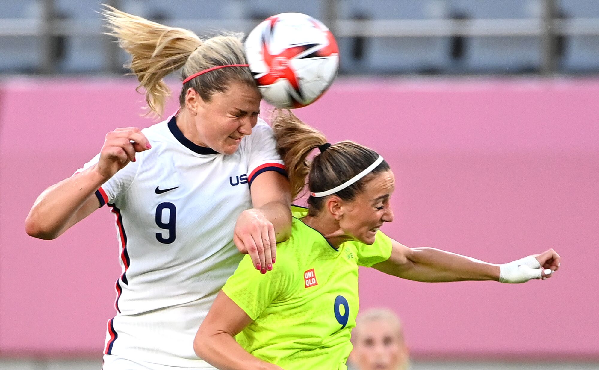 USA's Lindsey Horan hits the ball with her head as she battles for it with Sweden's Kosovare Asllani, who is in front of her