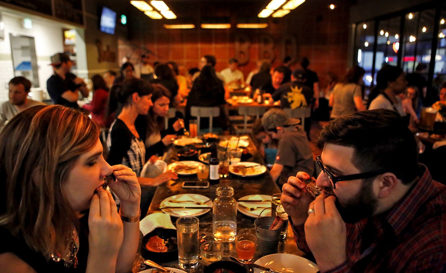 Devon Handy and her husband, Alex, dig into the spare ribs at Barrel & Ashes.