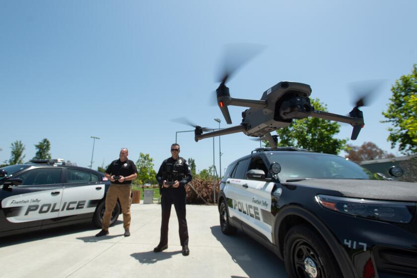 A drone lifts off under the guidance of Fountain Valley Police Sgt. Brian Mosher and Officer Anthony Clements at Fountain Valley Sports Park on June 18.