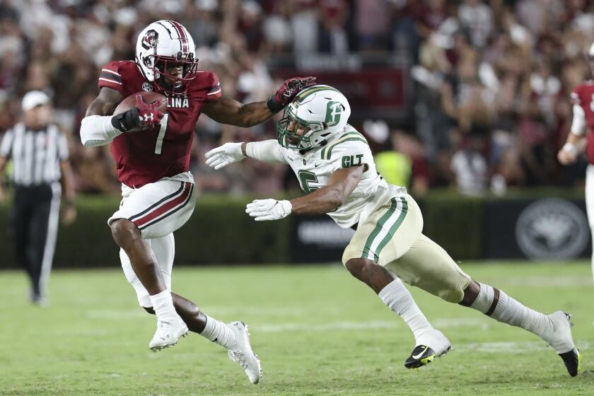 South Carolina running back MarShawn Lloyd (1) fends off Charlotte defensive back Solomon Rogers (6) during the first half of an NCAA college football game Saturday, Sept. 24, 2022, in Columbia, S.C. (AP Photo/Artie Walker Jr.)