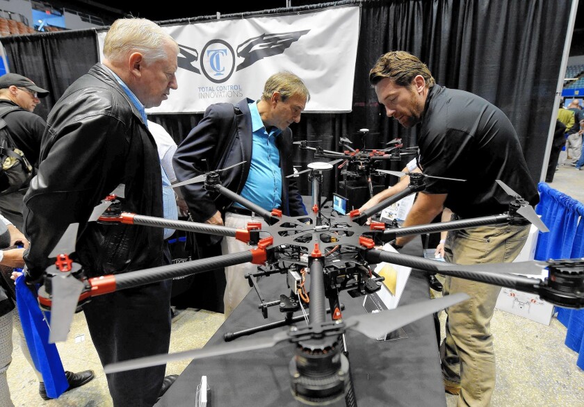 Staff from Total Control Innovations demonstrate a drone during the commercial drone industry’s first expo in L.A. this month.