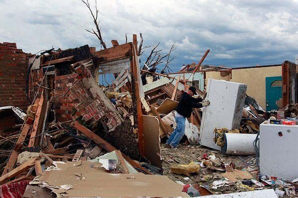 Rodney Heltcel salvages items from the wreckage of his home of 21 years that was destroyed Monday when a tornado moved through Moore, Okla.