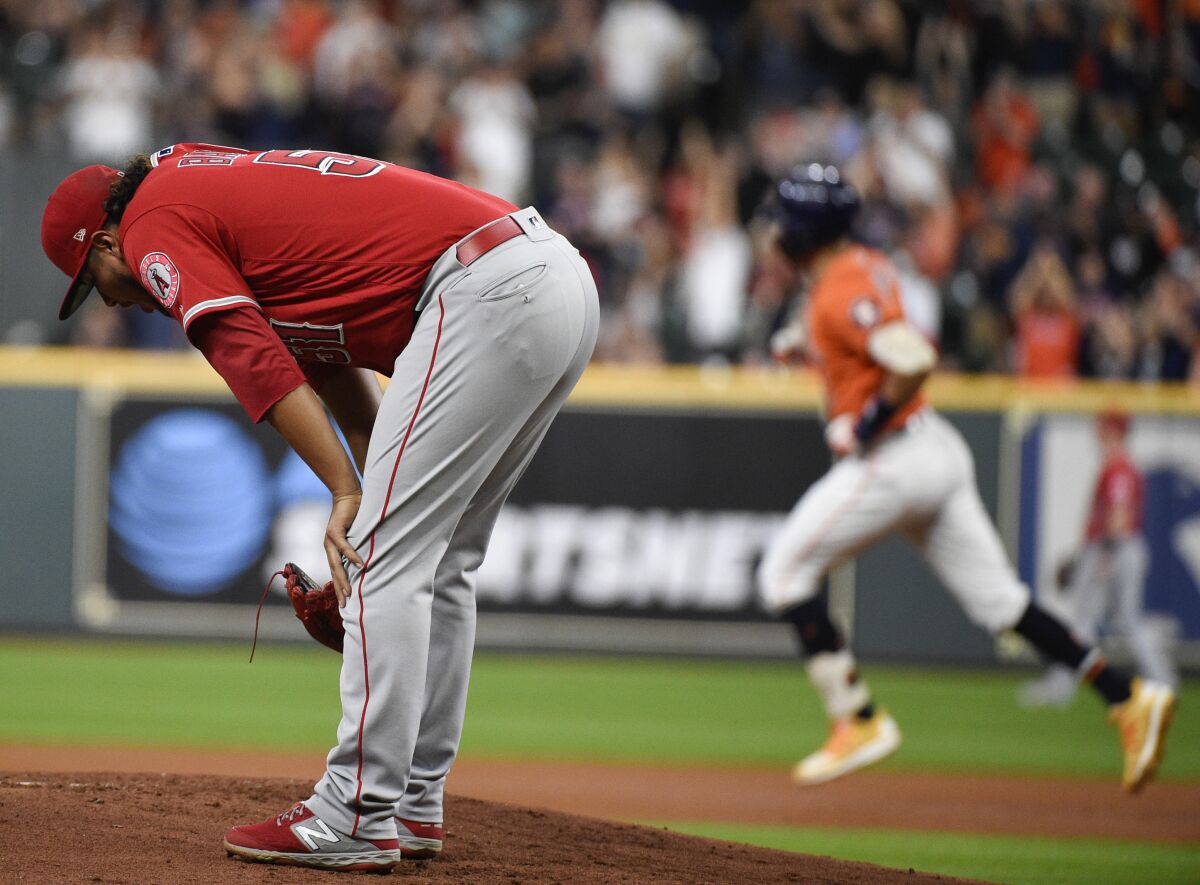 Angels pitcher Jaime Barria reacts after giving up a two-run homer to the Astros' Carlos Correa, background, on Sept. 20, 2019.