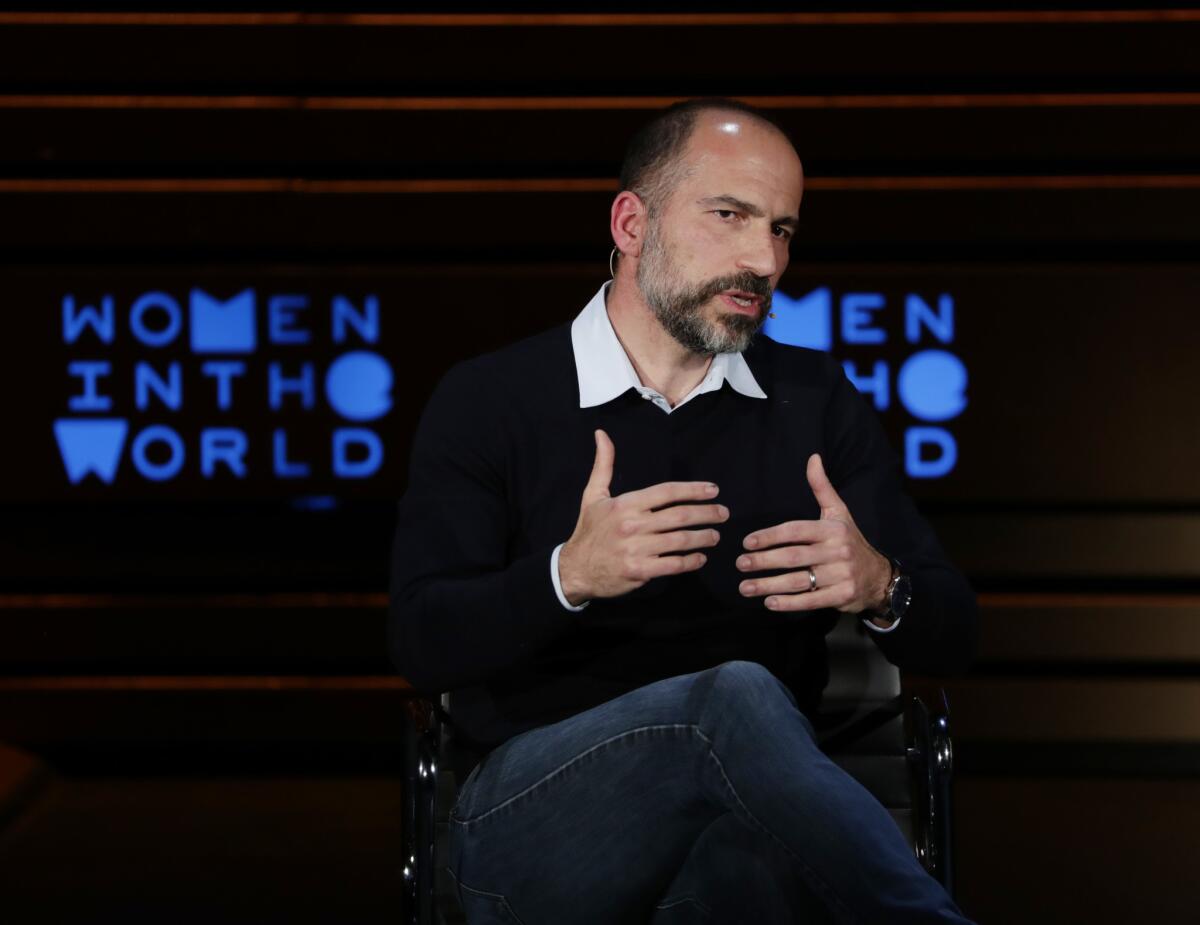 Uber CEO Dara Khosrowshahi gestures while he speaks seated onstage at the Women in the World summit