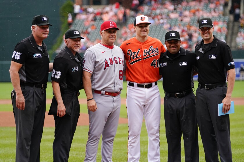 Angels interim manager Phil Nevin and his son, Orioles third baseman Tyler Nevin, pose with the umpiring crew July 9, 2022.