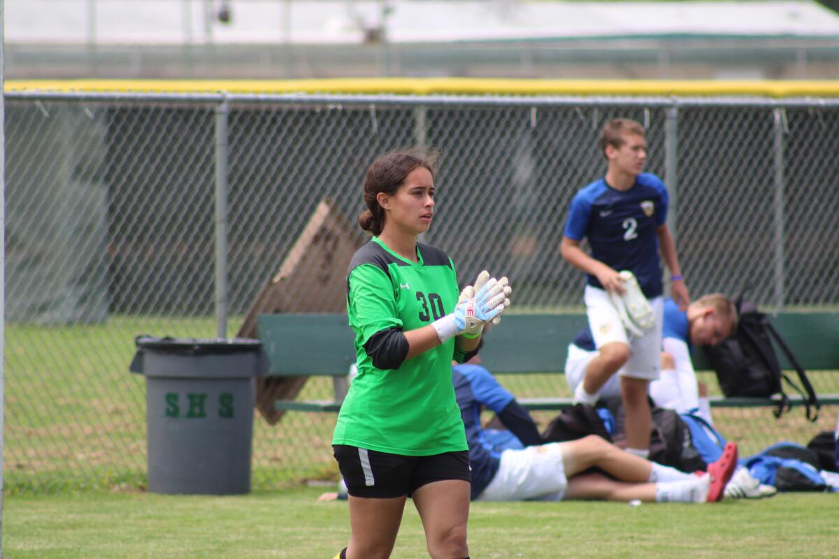 Melanie Rodriguez stands on the field during a team practice session.